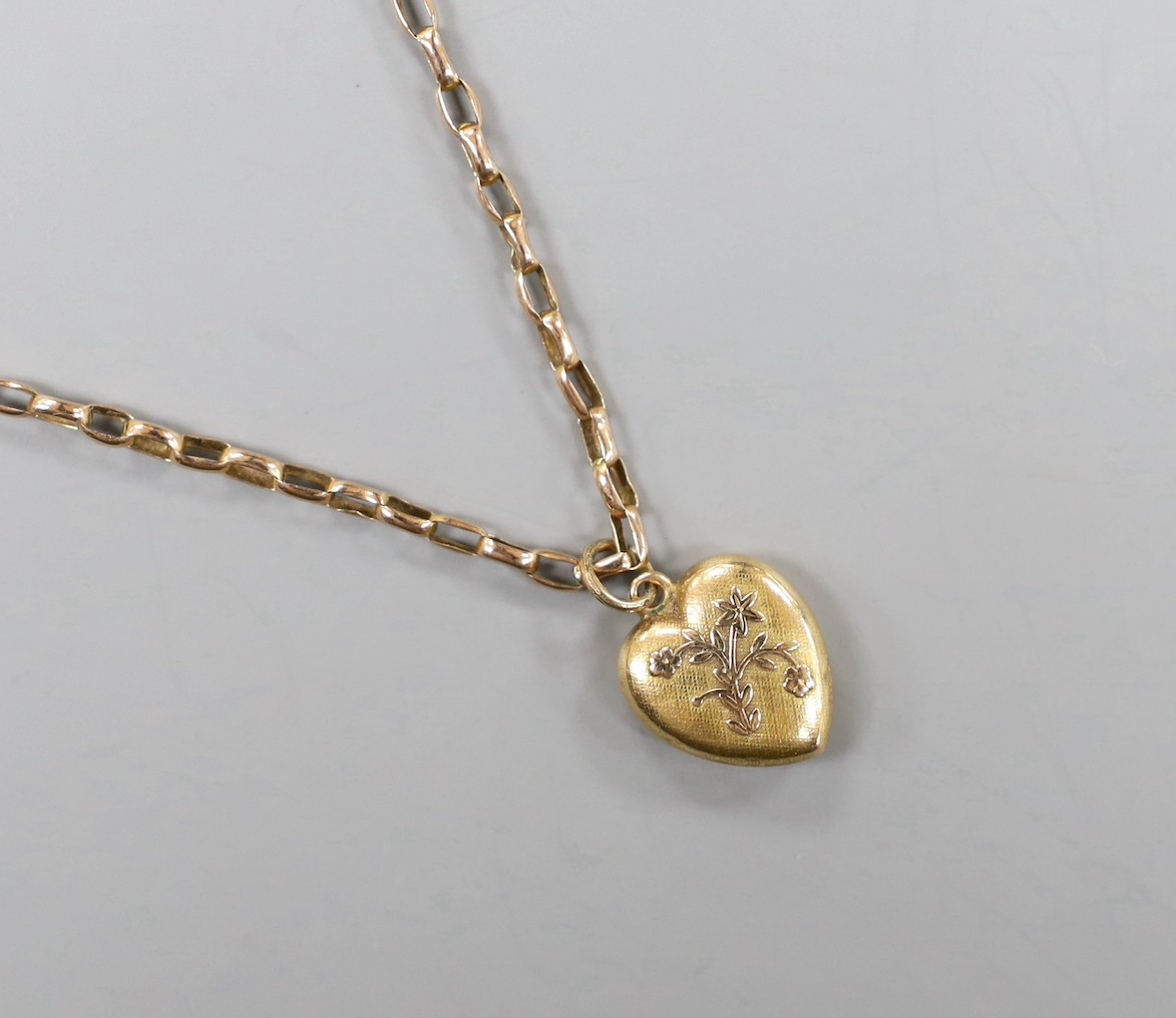 A yellow metal curb link necklace, 51cm, with a 15ct gold heart shaped charm, gross 5.6 grams